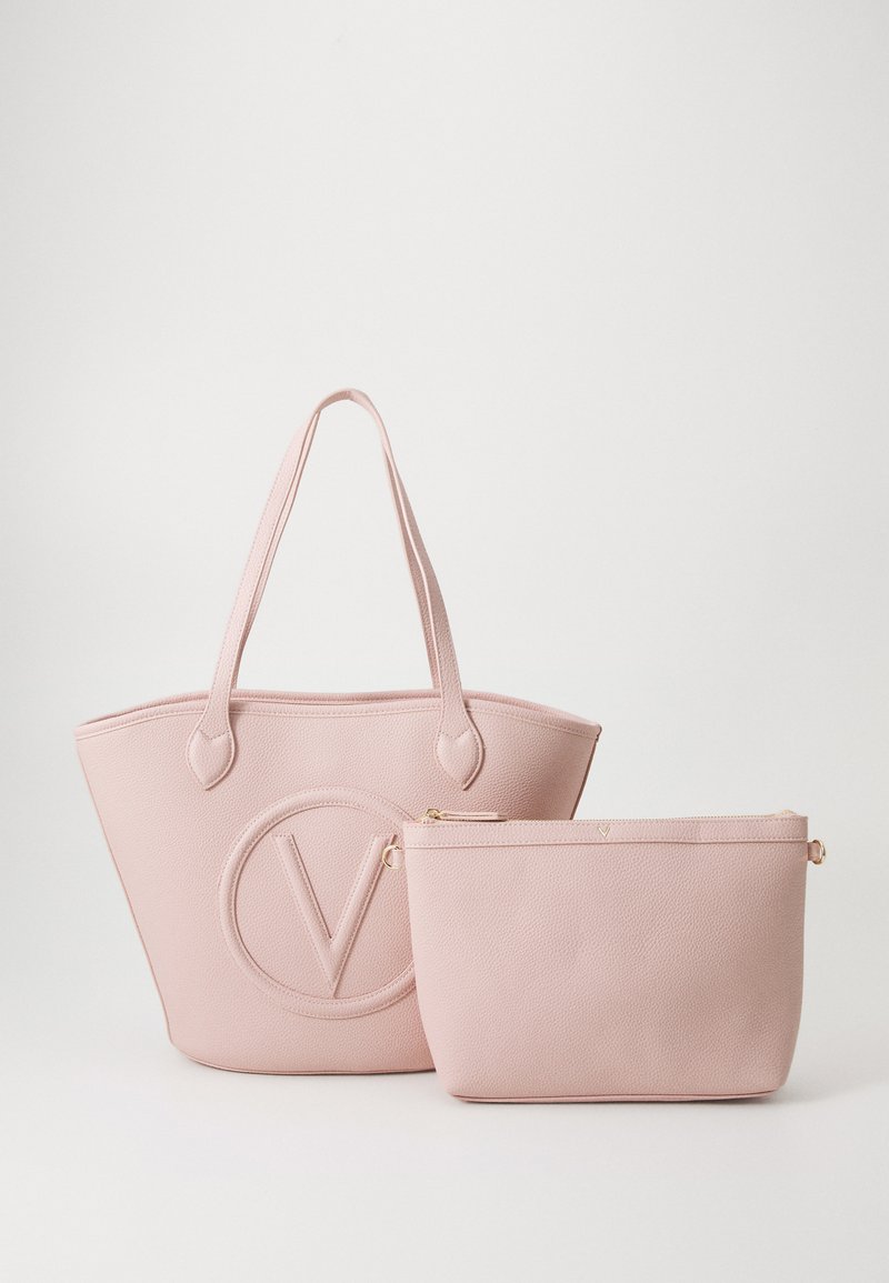 Rosa pebble-læder tote med dobbelte håndtag, prydet med et rundt logo; inkluderer en matchende lynlåspung med guldtonet hardware.