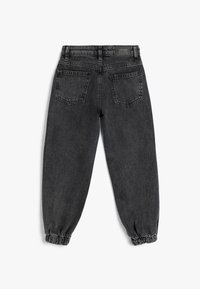 Mustat farkut, joissa on joustava vyötärö ja hihansuut, kahdella takataskulla ja vyötäröllä "KIDS"-label.