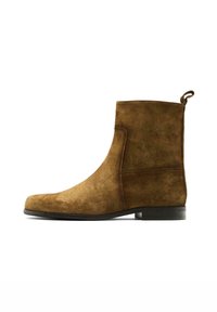 Brauner Wildleder-Stiefelette mit runder Spitze, seitlichen Steppnähten und einer kleinen Lasche hinten. Die Sohle ist flach und schwarz.