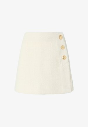 Witte, textuurvolle rok met een uitlopende vorm, voorzien van drie gouden knopen aan de zijkant en een subtiele zakdetail.