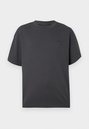 T-shirt de manga curta em cinza escuro com um pequeno logotipo discreto no lado esquerdo do peito, exibido sobre fundo branco.