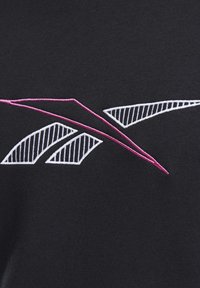 Bordado geométrico abstracto con formas triangulares blancas a rayas y líneas delineadas en rosa que se intersectan sobre una tela negra.