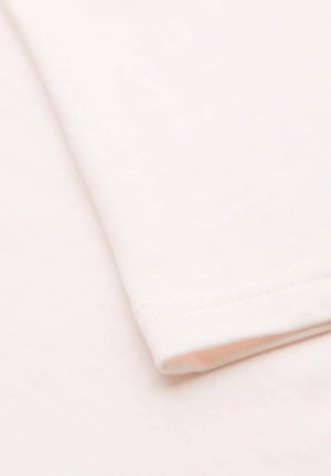 Tessuto in cotone rosa chiaro con una texture liscia, caratterizzato da un bordo della manica piegato ordinatamente e una sottile cucitura decorativa.