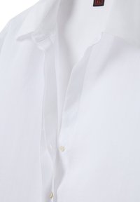 Camicia bianca con colletto classico, in tessuto morbido e piccoli bottoni beige lungo la patta. Texture liscia senza fantasie.