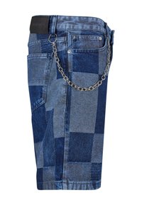 Traperice kratke hlače s patchwork dizajnom u različitim nijansama plave, s metalnim lančićem pričvršćenim na petlju za remen.
