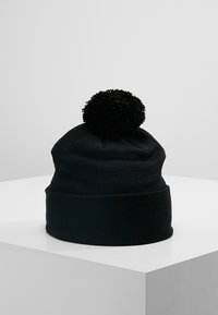 Black knit beanie with a textured finish and a large pom-pom on top. The hat has a rolled cuff design for added warmth.