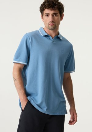 Lichtblauw poloshirt met een gestructureerde stof, voorzien van een klassieke kraag, witte strepen op de mouwen en een klein logo op de borst.