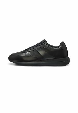 Sort lavtop læder-sneaker med snørelukning foran, perforerede sidepaneler og en tyk polstret sål, vist i højre sideprofil.