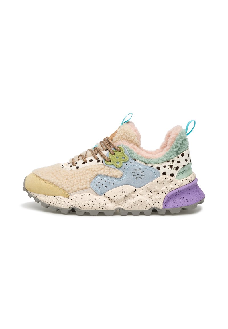 Sneaker multicolore avec une tige texturée en crème, bleu et vert, présentant une semelle mouchetée et un talon violet contrastant.