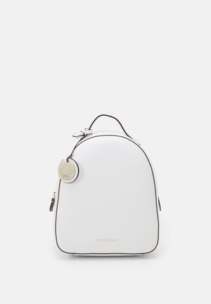 Sac à dos blanc avec bordure noire, poignée supérieure, poche avant zippée et porte-clés métallique rond suspendu sur le côté sur fond uni.