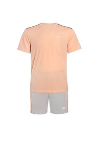 Maglietta atletica a maniche corte color pesca con una sottile trama a righe, abbinata a pantaloni corti grigi chiari con motivi laterali e logo.