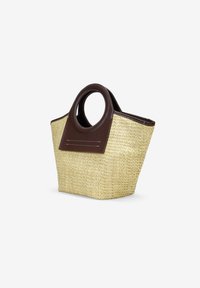 Bolso de paja trenzada con asas de cuero marrón oscuro y una base plana y rectangular. Presenta costuras en el panel de cuero.