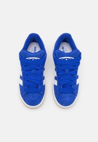 Μπλε σουέτ αθλητικά παπούτσια με λευκές ρίγες, στρογγυλή μύτη, δομημένος σχεδιασμός, επίπεδες κορδόνες και καουτσούκ σόλα; δεν υπάρχουν ορατά λογότυπα.