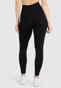 Zwarte high-waisted leggings van rekbaar materiaal, met een gladde textuur, aangesloten ontwerp en lengte tot de enkels.