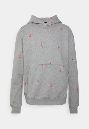 Sweat à capuche gris en tissu doux, avec une poche kangourou. Il présente de petits motifs rouges représentant des figures et des "J" dispersés sur toute la surface.