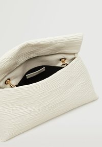 Biała torebka kopertowa o teksturowanej powierzchni z czarnym wnętrzem. Zapięcie ma złote okucia, zaś wnętrze jest gładkie, a na zewnętrznej stronie występuje subtelny wzór fal.