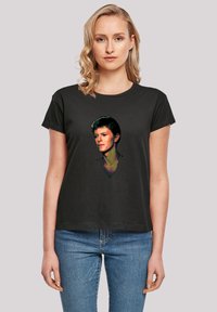 Black cotton t-shirt featuring a colorful graphic print of a male portrait on the front. Short sleeves and casual fit design.
