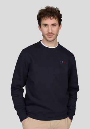 Sweatshirt bleu marine en mélange de coton, avec un col rond, des manches longues, et un petit logo brodé en rouge, blanc et bleu.