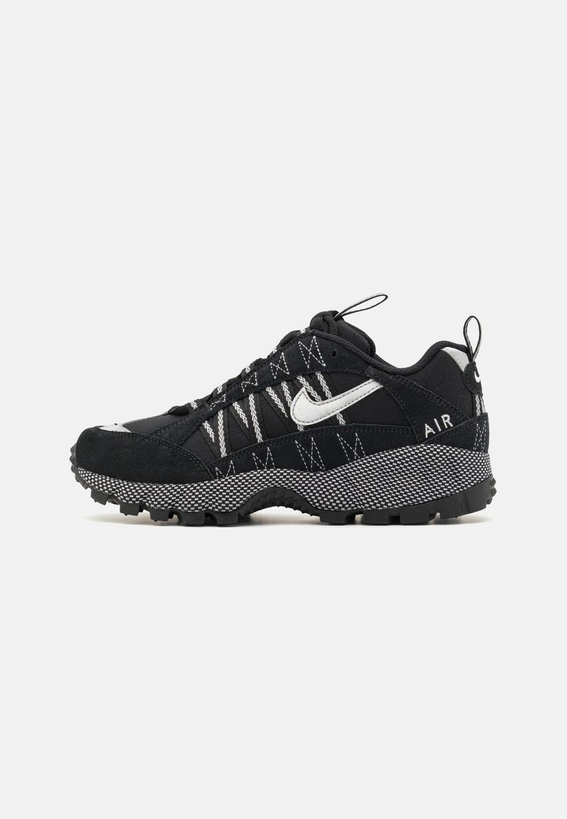 Baskets Nike Air noires avec logo Swoosh blanc, semelle épaisse texturée, et languettes réfléchissantes sur la languette et le talon.