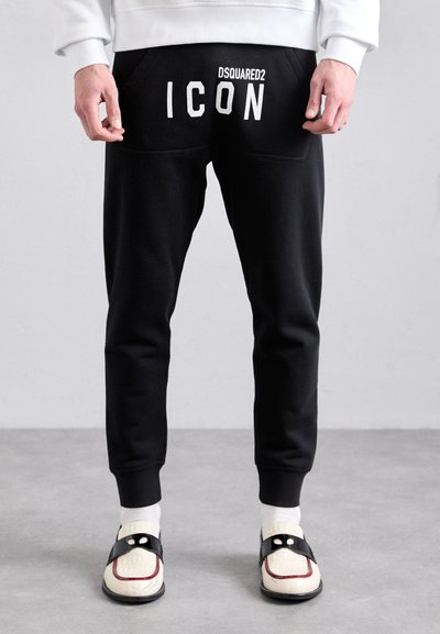 Pantalons de jogging noirs à coupe slim, avec un imprimé blanc "DSQUARED2 ICON" à l'arrière, taille élastique et chevilles ajustées.