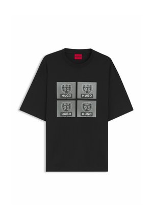 T-shirt noir à manches courtes avec quatre patchs carrés gris, chacun affichant un écusson "Road 93" et le texte "HUGO" en blanc.