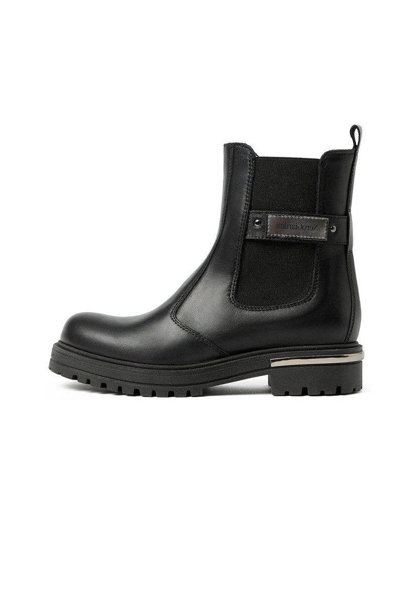 Stivaletto in pelle nera con pannelli laterali elasticizzati e un accento metallico decorativo sul tacco. Suola robusta con un profondo motivo di battistrada.