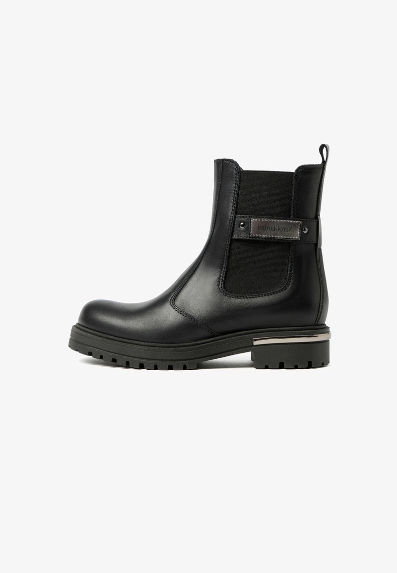 Zwarte leren enkelboot met elastische zijpanelen en een decoratieve metalen accent op de hak. Robuuste zool met een diep profiel.