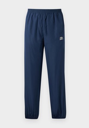 Námořnické modré sportovní kalhoty Umbro s elastickým pasem a manžetami, bočními kapsami a logem Umbro na levém stehně.