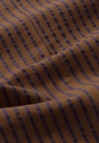 Bruin stof met donkerblauwe verticale strepen, klassiek patroon, zachte textuur, lichte glans en een elegante val. Geschikt voor kleding of meubels.