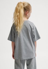 Grau Baumwoll-T-Shirt mit kurzen Ärmeln, lockerer Passform und rundem Halsausschnitt, kombiniert mit passenden grauen Hosen. Keine sichtbaren Muster oder Akzente.