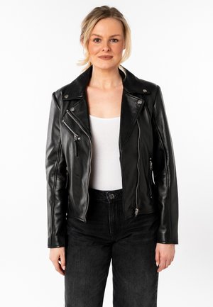 Zwarte leren motorjack met een gekartelde kraag, asymmetrische rits en ritszakken. Draag het over een witte top en zwarte spijkerbroek.