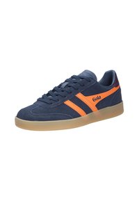 Marinblå mocka sneakers med orange randiga detaljer, rund tå, texturerad yta och en genomskinlig gumminsål. Har snörningsstängning.