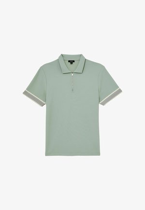 Tricou polo cu mâneci scurte de culoare verde deschis, cu guler cu fermoar și mansete dungi pe mâneci, așezat plat pe un fundal alb.