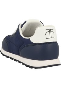 Tennarit tummansinisellä värillä, jossa on teksturoitu synteettinen päällinen, valkoiset koristeet, nauhakiristys ja musta kumipohja. Takana logomerkintä.