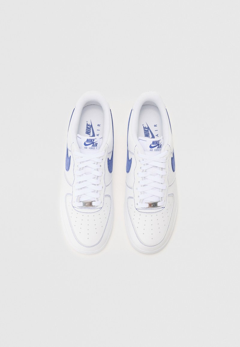 Baskets Nike Air Force 1 en cuir blanc avec des accents bleus. Comprend un bout arrondi, des perforations, des lacets blancs et un logo sur la languette.