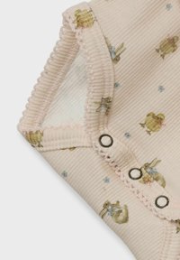 Tissu gaufré rose avec un motif floral comportant de petits lapins. Détails notables incluent une délicate bordure festonnée et des boutons-pression fonctionnels.