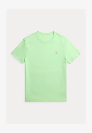 Lys grønn bomulls-T-skjorte med rund hals og korte ermer. Har en liten oransje logo på venstre bryst. Glatt tekstur.