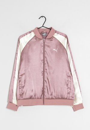 Pinkfarbene Satin Puma Trainingsjacke mit weißen Streifen an den Ärmeln, Frontreißverschluss sowie geripptem Kragen, Bündchen und Saum, aufgehängt an einem schwarzen Bügel.