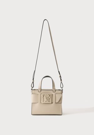 Sac à main en cuir beige avec poignées supérieures, sangle longue réglable, poches avant et logo AX embossé au centre.