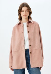 Rosa mockajacka med krage, med en knäppning framtill, breda ärmar och en något boxig passform. Matcher med blå denim.