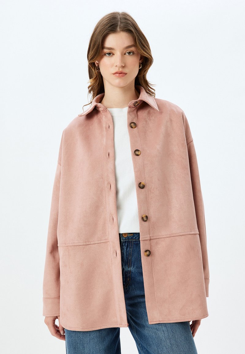 Rosa mockajacka med krage, med en knäppning framtill, breda ärmar och en något boxig passform. Matcher med blå denim.
