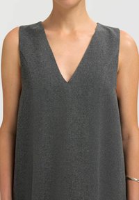 Graues ärmelloses Kleid mit tiefem V-Ausschnitt. Hergestellt aus weichem, strukturiertem Stoff, mit klaren Linien und einer lässigen, fließenden Passform.