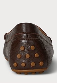 Brown leather loafers featuring a textured design, rounded back, and rubber studs on the sole for traction.