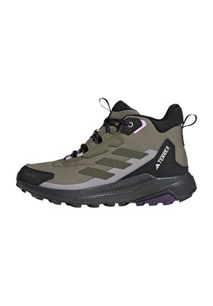Wysokie buty trekkingowe w oliwkowej zieleni z czarnymi i szarymi akcentami, czarną podeszwą, sznurowadłami, pętelkami i logo TERREX po boku.