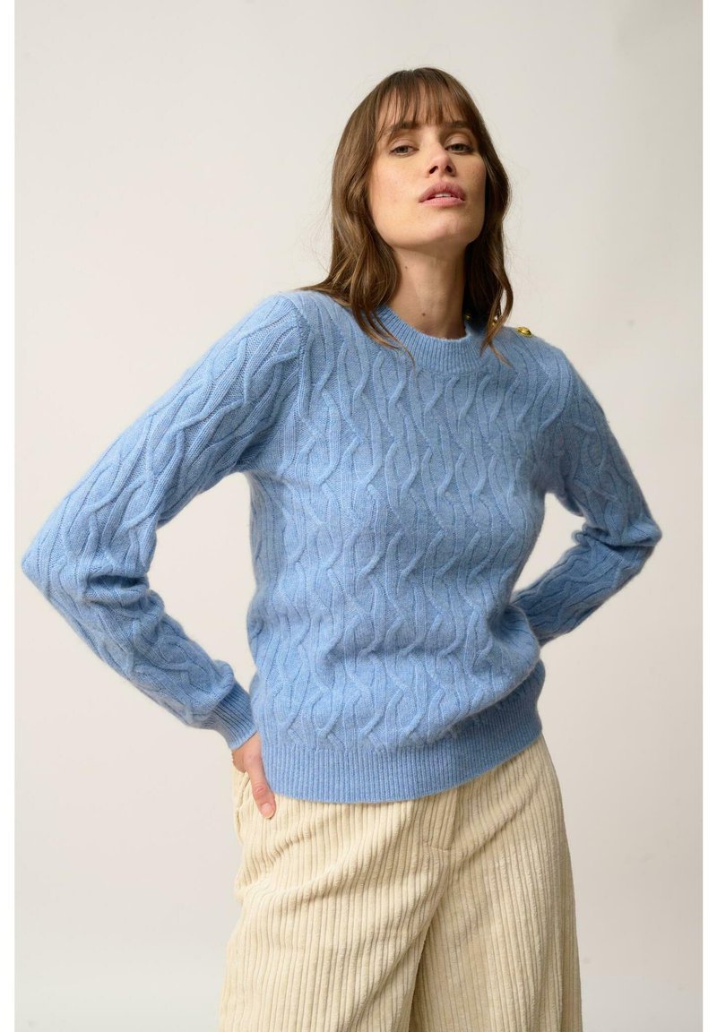 Jasnoniebieski sweter z dzianiny w warkocze, z okrągłym dekoltem i fakturowanym wzorem. Zawiera złote guziki akcentujące na ramieniu.
