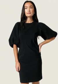 Schwarzes Kleid mit Puffärmeln, taillierter Oberteil und knielangem Saum. Glatte Textur mit leichtem Stretch. Schlichtes Rundhalsdesign, ohne sichtbare Muster.
