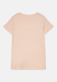 Kortermet t-skjorte i myk, blush rosa stoff med rund hals og rett søm. Har minimale sømmer for en ren finish.