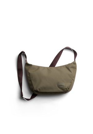 Compact olive green crossbody bag with adjustable dark brown strap and small brand logo on front, isolated on white background.