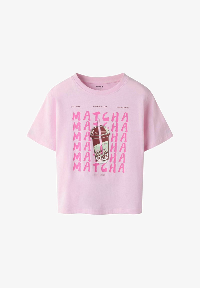Jasnoróżowa koszulka z ilustracją kubka bubble tea oraz powtarzającym się różowym napisem "MATCHA", promująca japońską matchę i organiczne składniki.