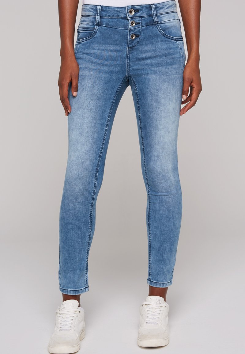 Vaqueros de mezclilla azul claro con un ajuste Slim, que cuentan con una cintura alta y cierre de tres botones. Textura suave con bolsillos básicos en la parte delantera y trasera.
